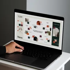 Laptop mit geöffneter Website, Hand am Touchpad, Symbol für Entwicklung einer Markenstrategie