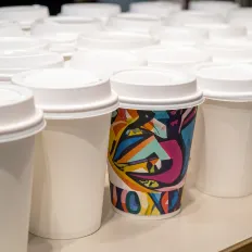 Weiße Kaffeebecher, einer mit farbigem Design, steht für Marken-Differenzierung